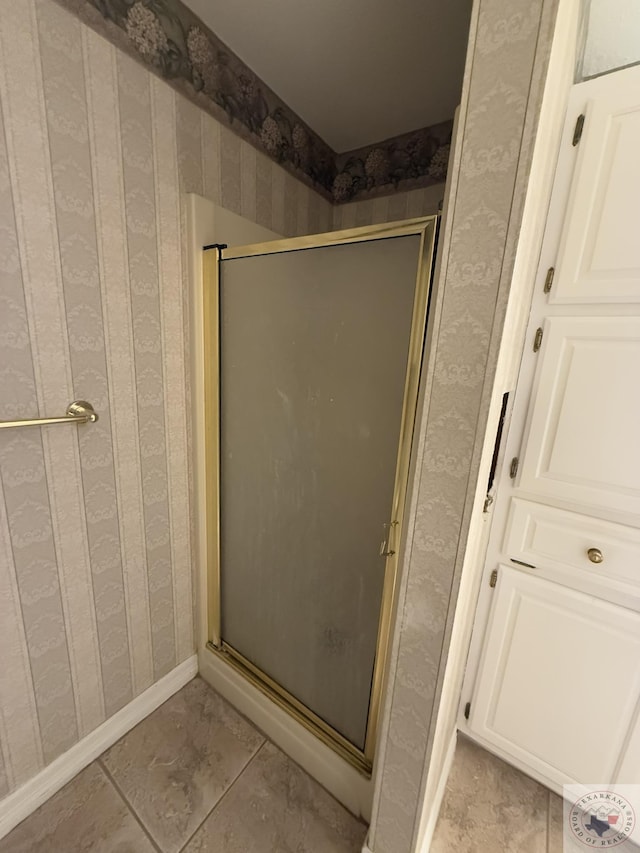 bathroom featuring a shower with shower door and tile patterned flooring