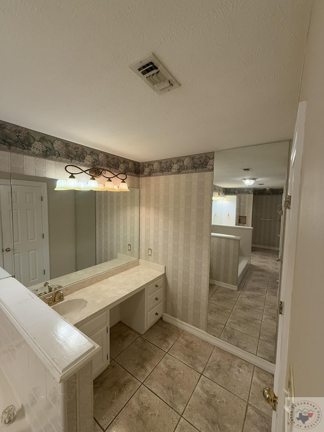 bathroom with a textured ceiling, tile patterned floors, and vanity