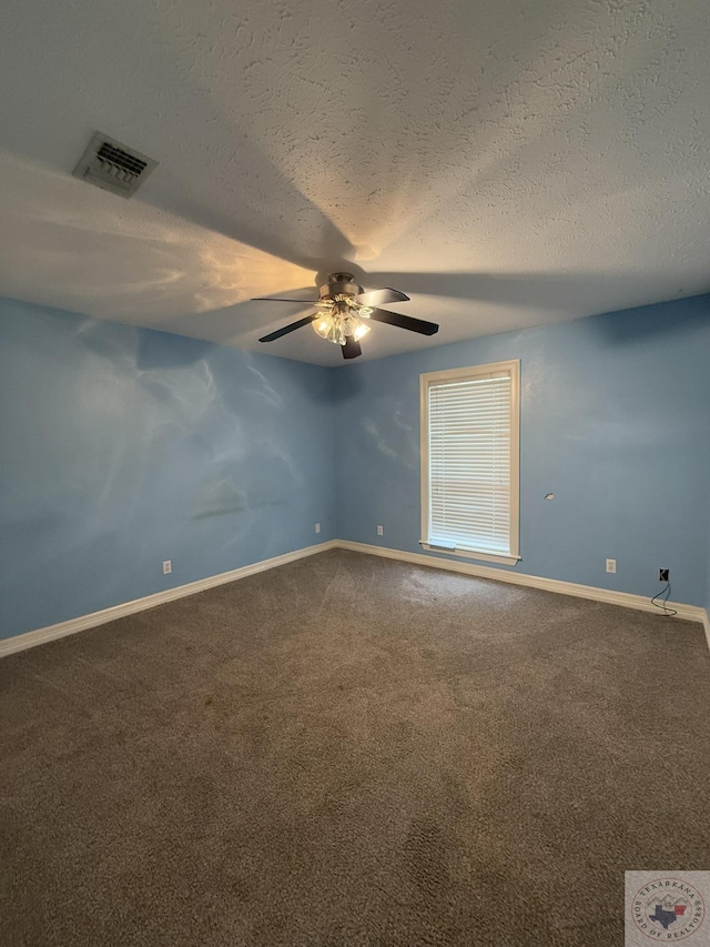 carpeted spare room featuring ceiling fan and a textured ceiling