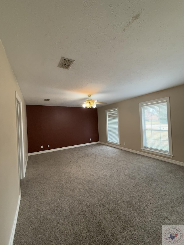 spare room with a textured ceiling and carpet floors