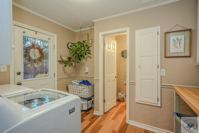 clothes washing area featuring washer / dryer, crown molding, and light hardwood / wood-style floors