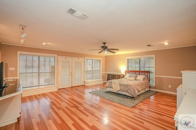 bedroom with ceiling fan, light hardwood / wood-style floors, ornamental molding, and french doors