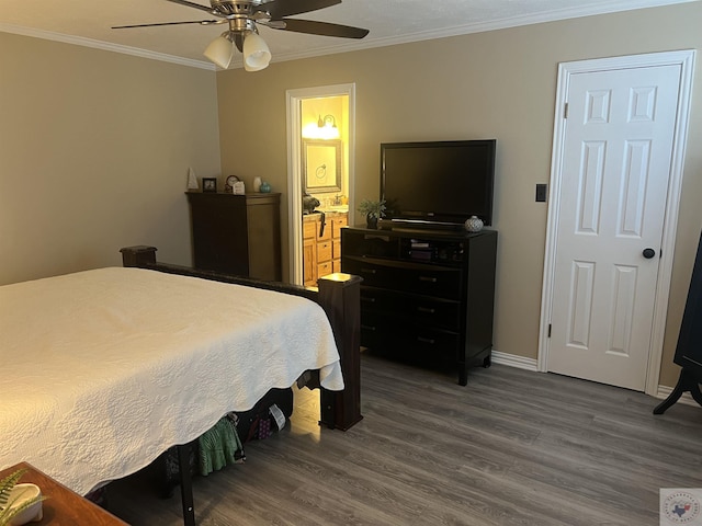 bedroom with ceiling fan, connected bathroom, crown molding, and dark wood-type flooring