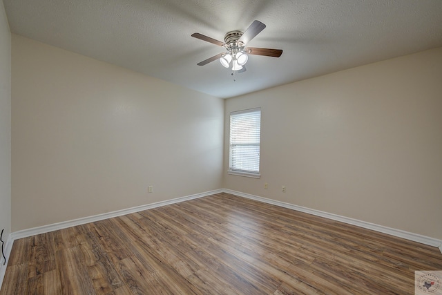 unfurnished room featuring ceiling fan, dark hardwood / wood-style floors, and a textured ceiling