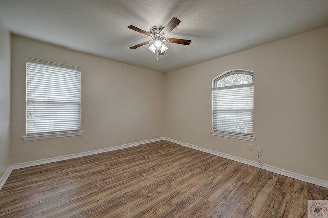 unfurnished room featuring dark wood-type flooring and ceiling fan
