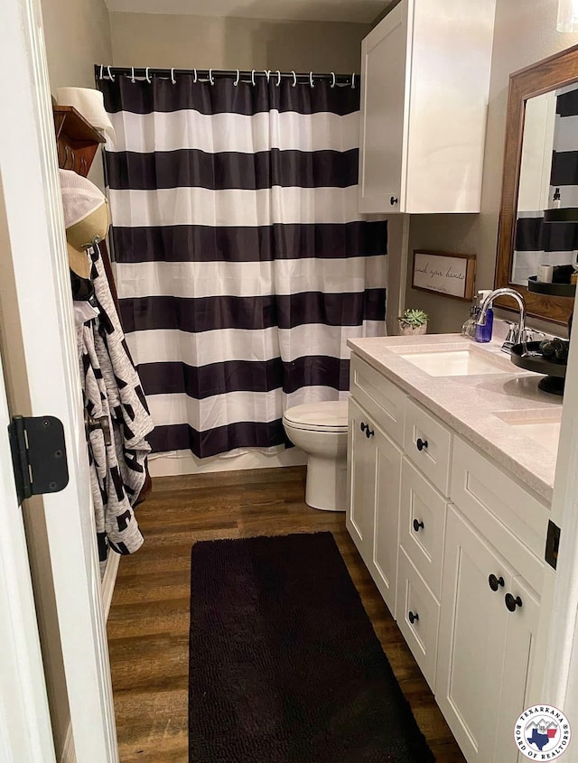 19 Hidden Valley Rd, Texarkana, TX 75501 - bathroom with wood finished floors, toilet, double vanity, and curtained shower