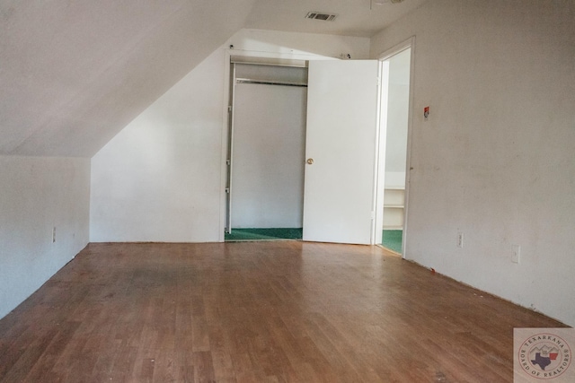 bonus room with hardwood / wood-style flooring and vaulted ceiling