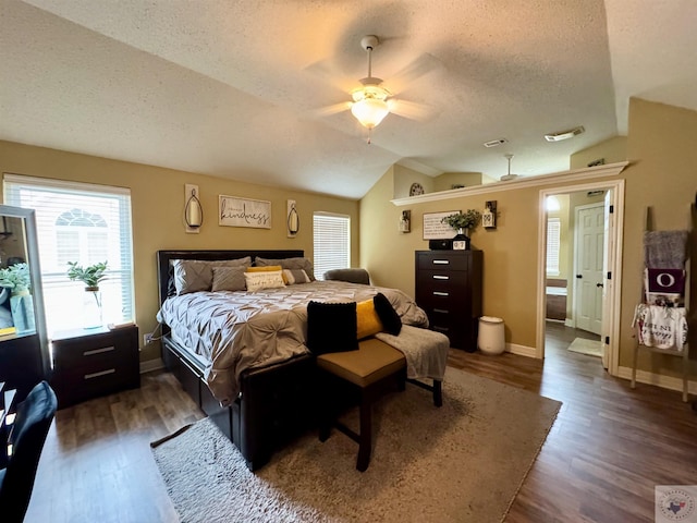 bedroom with vaulted ceiling, a textured ceiling, baseboards, and wood finished floors