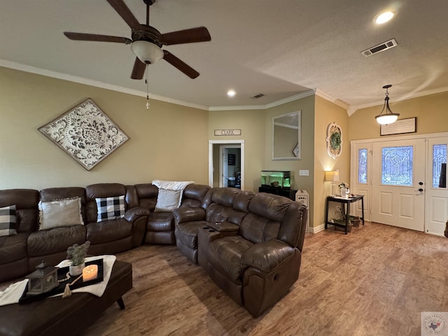 living room with baseboards, visible vents, wood finished floors, crown molding, and recessed lighting