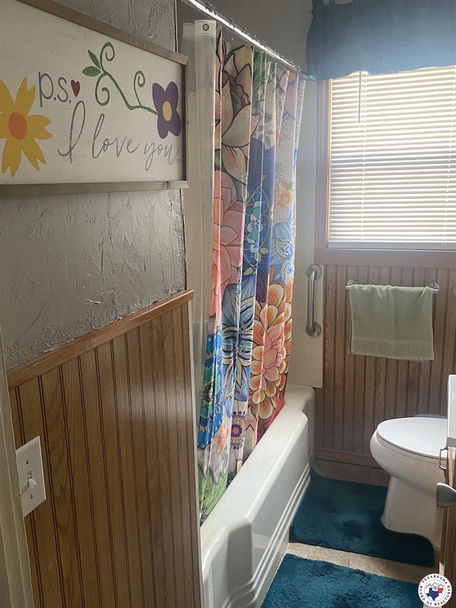 203 Patterson St, Naples, TX 75568 - bathroom featuring toilet, shower / tub combo with curtain, and wooden walls