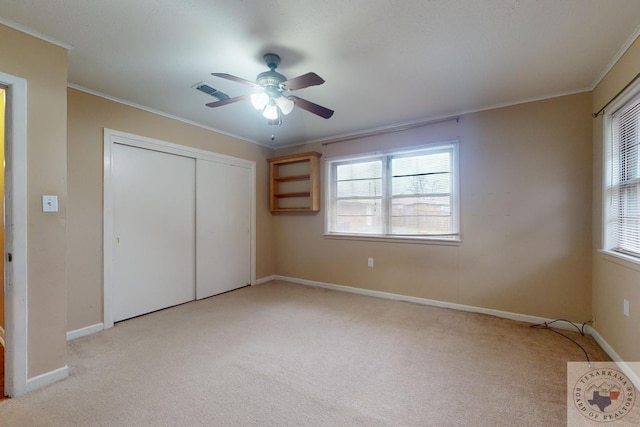 unfurnished bedroom with light carpet, a closet, ceiling fan, and ornamental molding