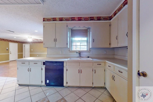 kitchen featuring sink, black dishwasher, light tile patterned floors, and a textured ceiling