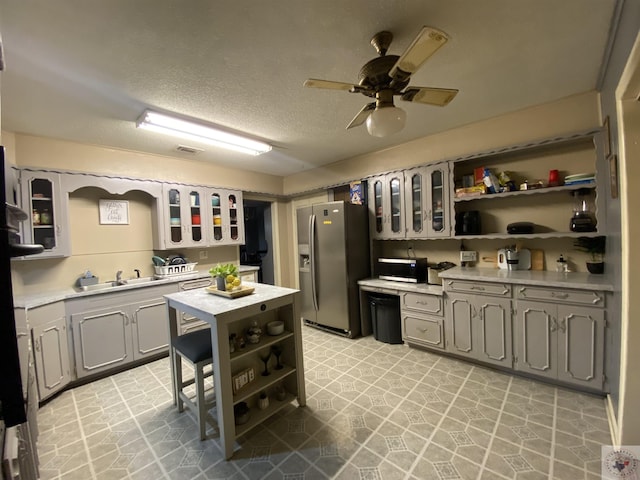 kitchen featuring stainless steel appliances, ceiling fan, a textured ceiling, and gray cabinets