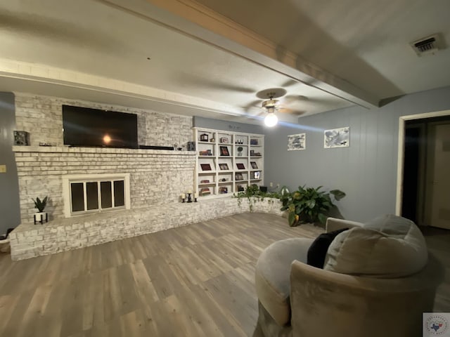 living room with ceiling fan, wood-type flooring, and beam ceiling