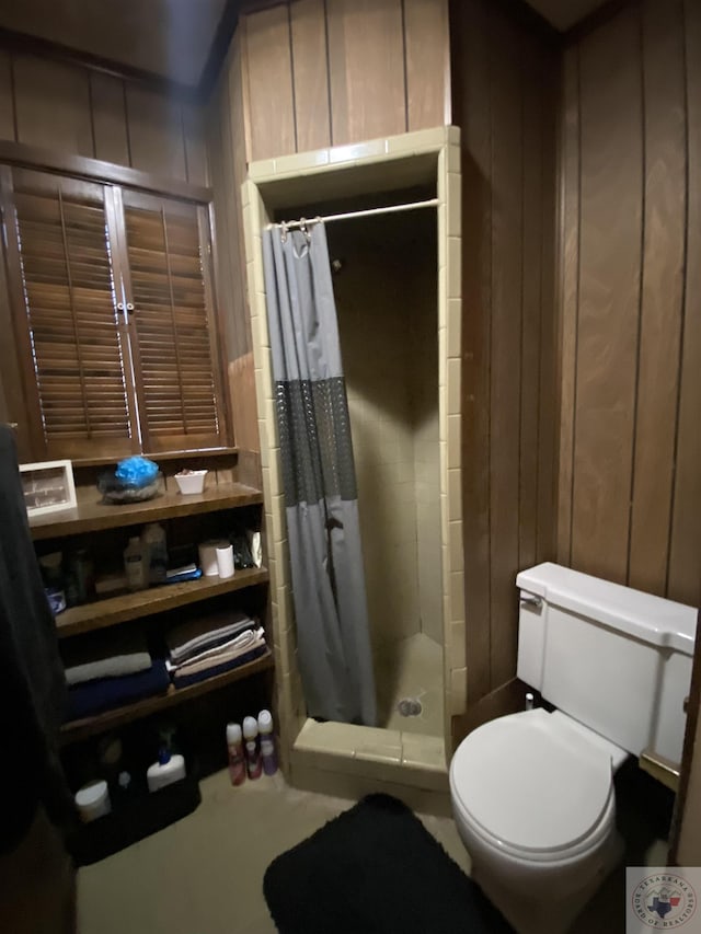 bathroom featuring toilet, wood walls, and a shower with curtain