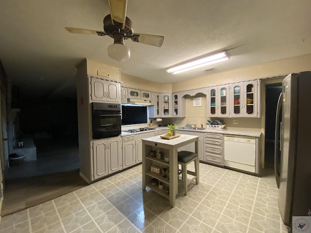 kitchen with a textured ceiling, black appliances, sink, ceiling fan, and gray cabinetry