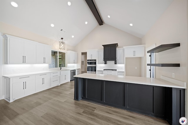 8405 Mandarin Cv, Texarkana, TX 75503 - kitchen with beamed ceiling, open shelves, white cabinets, and appliances with stainless steel finishes