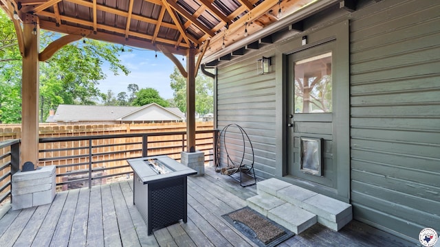 deck featuring a gazebo, an outdoor fire pit, and fence