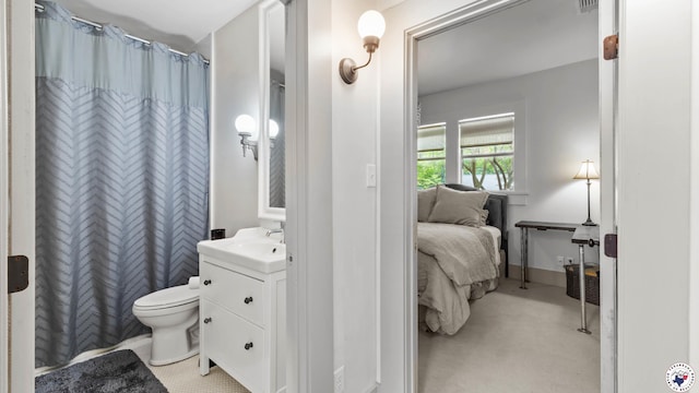 ensuite bathroom with connected bathroom, toilet, vanity, and a shower with shower curtain