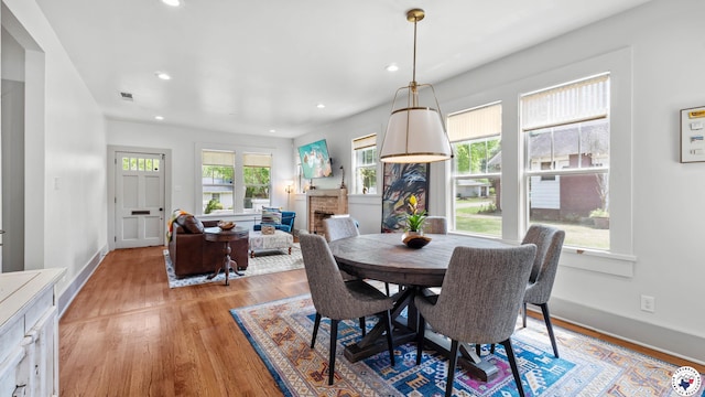 dining area featuring baseboards, visible vents, light wood finished floors, and recessed lighting