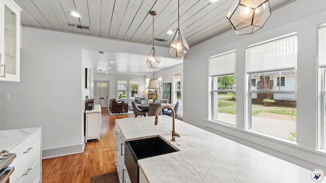 kitchen with visible vents, a sink, and white cabinetry