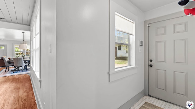entryway with baseboards, visible vents, and light wood-type flooring