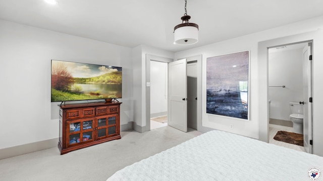 bedroom with ensuite bath and baseboards