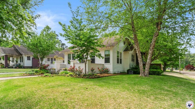 ranch-style house featuring stucco siding and a front yard