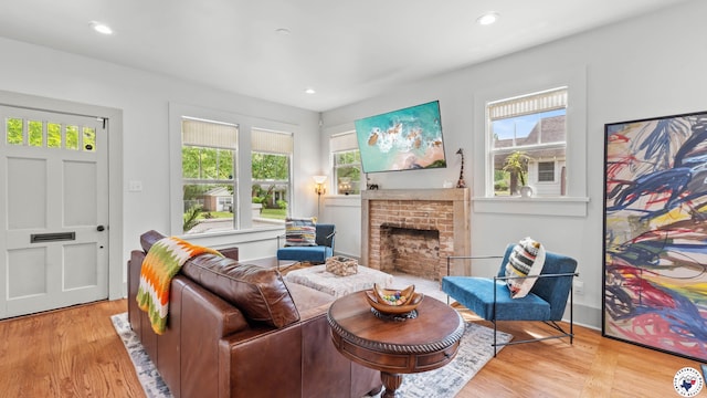 living area with a fireplace, wood finished floors, and recessed lighting