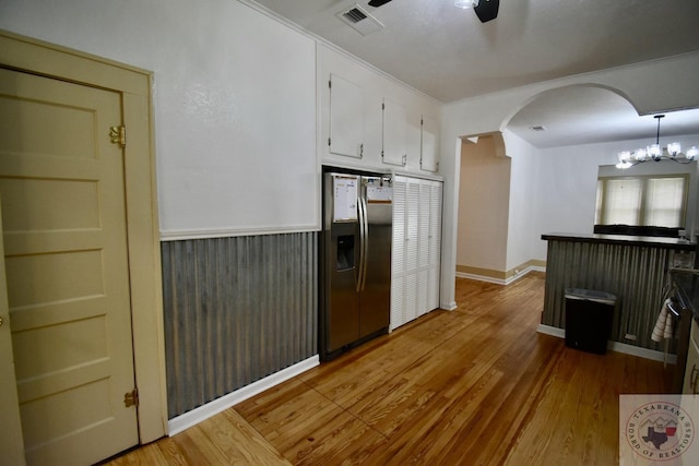 kitchen featuring ceiling fan with notable chandelier, stainless steel refrigerator with ice dispenser, white cabinetry, light hardwood / wood-style floors, and hanging light fixtures