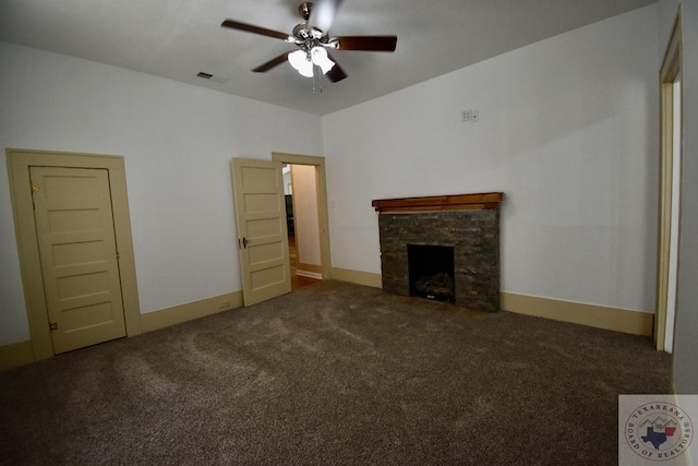 unfurnished living room with a fireplace, ceiling fan, and dark colored carpet