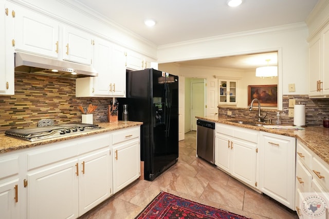 kitchen with light stone countertops, appliances with stainless steel finishes, decorative backsplash, sink, and white cabinets