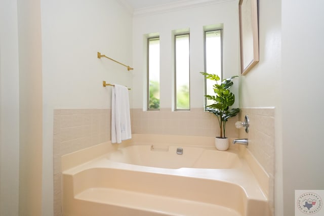 bathroom featuring a tub to relax in and crown molding