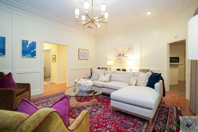 living room with light hardwood / wood-style floors, a chandelier, and ornamental molding