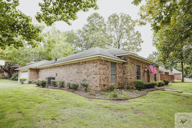 view of side of home featuring a garage, cooling unit, and a yard