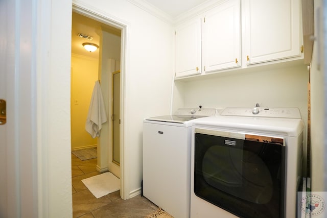 washroom featuring washing machine and dryer, crown molding, cabinets, and tile patterned floors