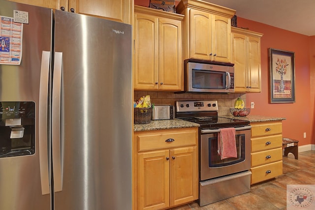 kitchen featuring light brown cabinetry, appliances with stainless steel finishes, light tile patterned floors, light stone countertops, and decorative backsplash