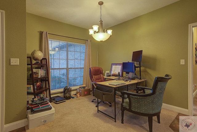 carpeted home office featuring a chandelier