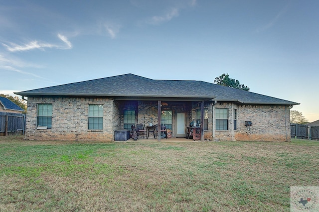 back of property with a patio and a yard