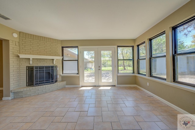 unfurnished sunroom featuring french doors and a fireplace