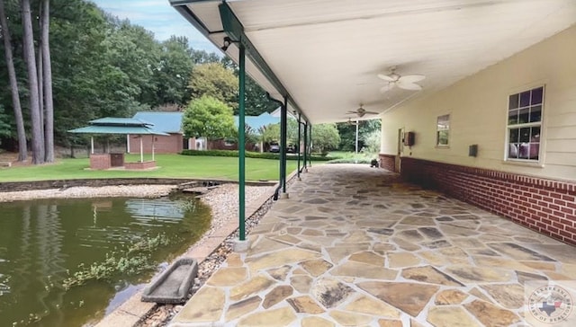 view of patio featuring ceiling fan and a water view