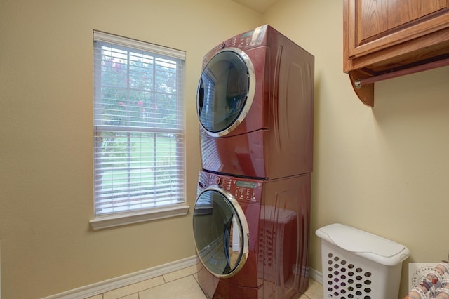 laundry room featuring light tile patterned floors and stacked washer and clothes dryer