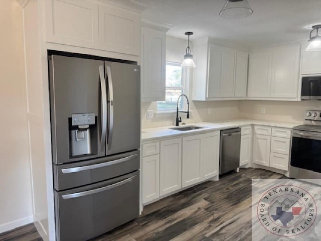 kitchen with sink, decorative light fixtures, dark wood-type flooring, white cabinetry, and stainless steel appliances