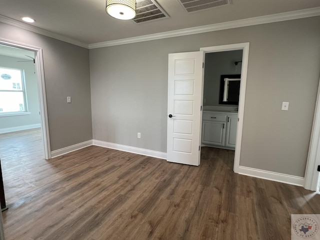 spare room with ornamental molding and dark wood-type flooring