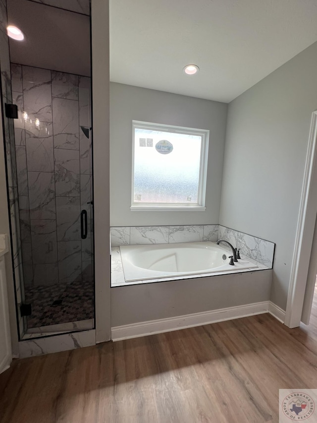 bathroom featuring hardwood / wood-style flooring and plus walk in shower