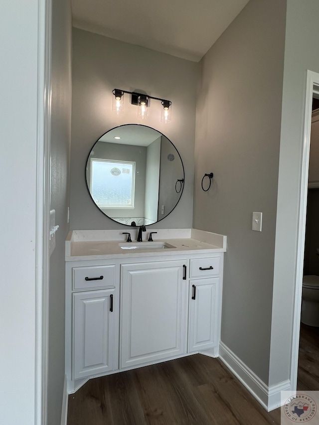 bathroom featuring vanity, hardwood / wood-style flooring, and toilet