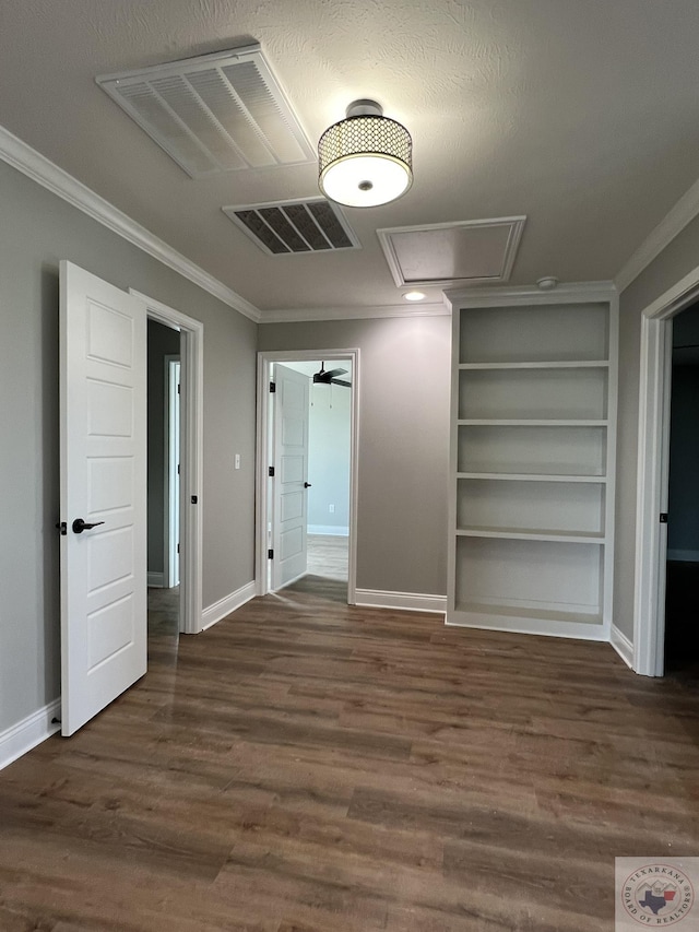 unfurnished bedroom with crown molding, a textured ceiling, and dark hardwood / wood-style floors