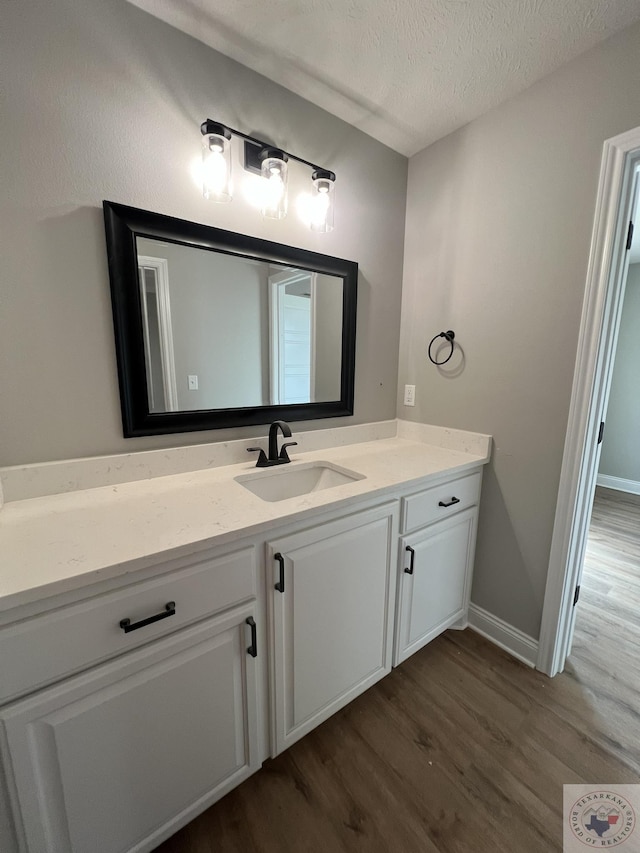 bathroom with vanity, hardwood / wood-style floors, and a textured ceiling