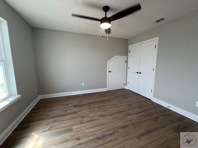 empty room with dark hardwood / wood-style floors and ceiling fan