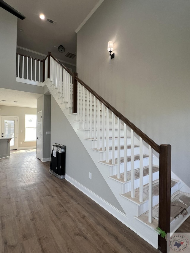 stairway with hardwood / wood-style flooring and crown molding